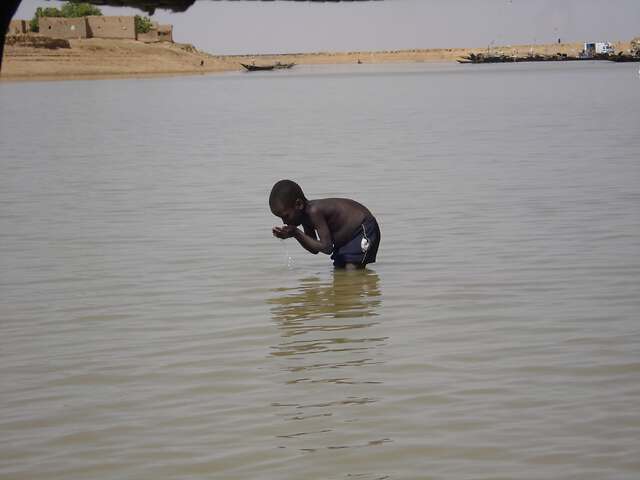 Enfant qui se lave dans le fleuve Niger au Mali