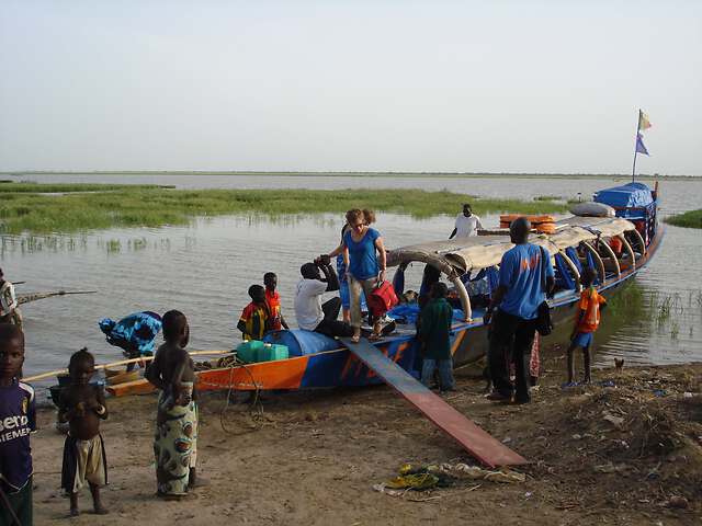 Pirogue de MÃ©decins du Fleuve qui dÃ©barque du matÃ©riel mÃ©dical au Mali